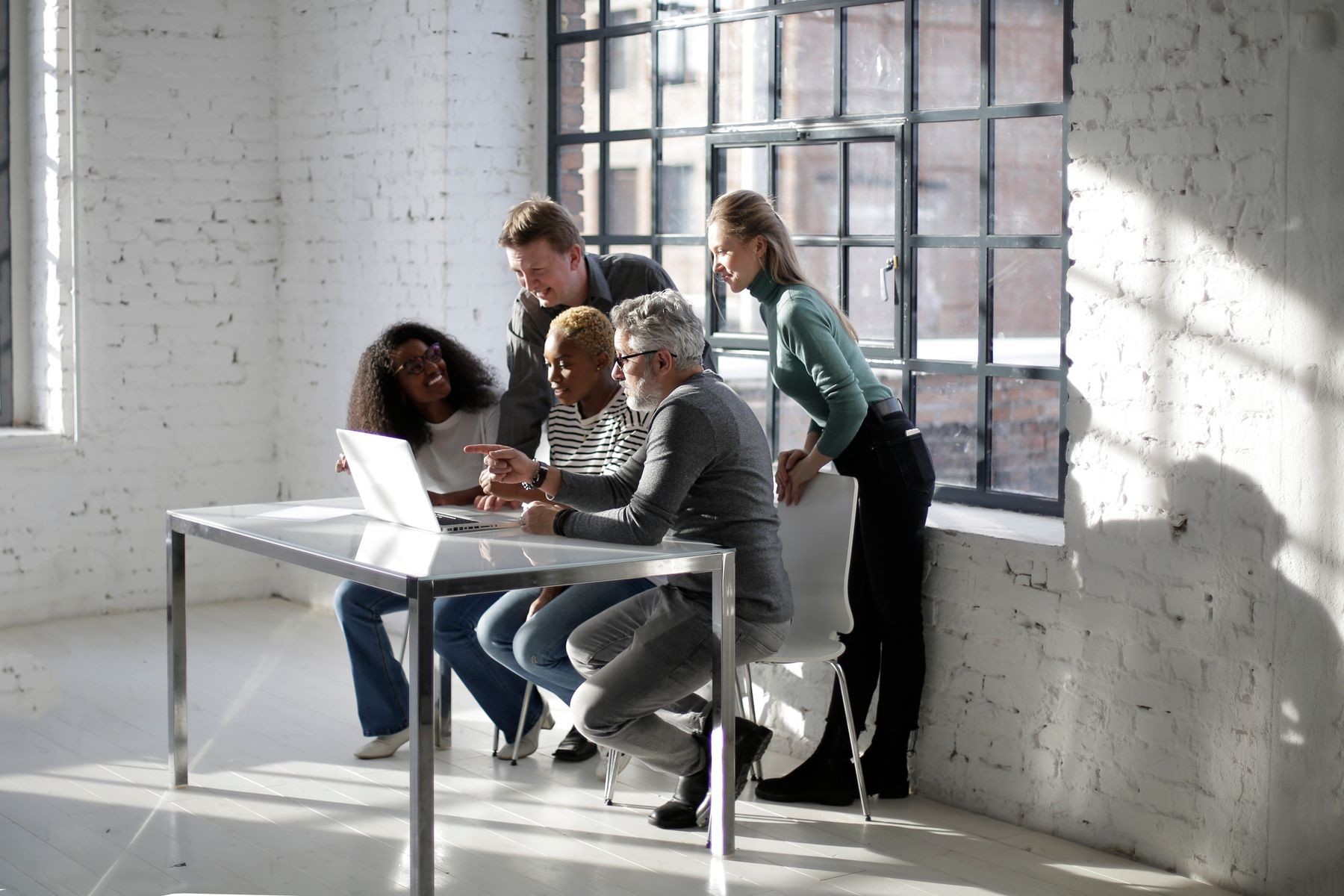 Colleagues collaborating around a laptop